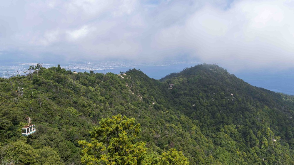宮島彌山山頂俯瞰景色,遠方可見山景、瀨戶內海以及小小的宮島纜車